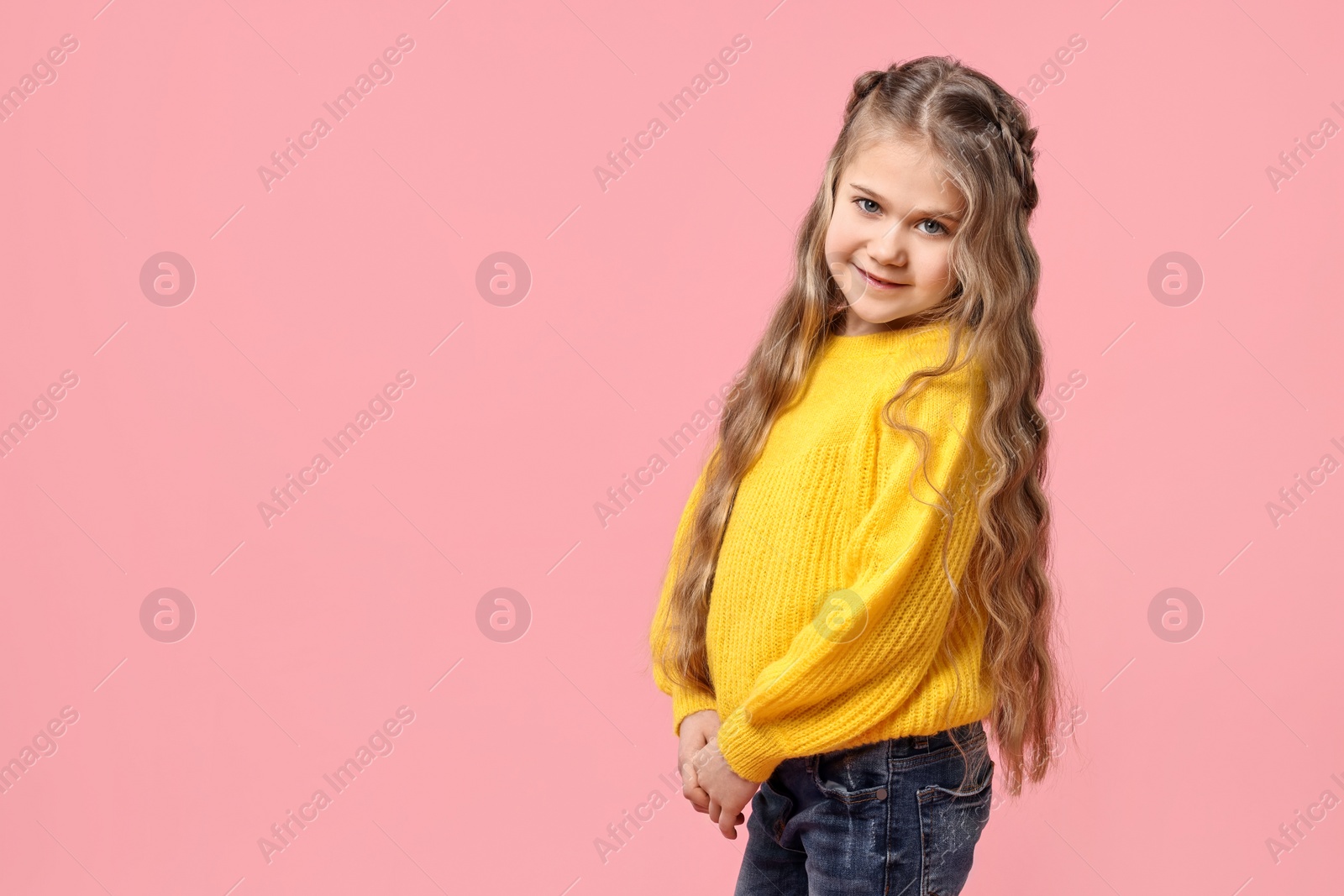 Photo of Cute little girl with braided hair on pink background. Space for text