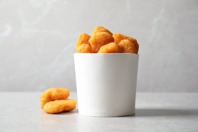 Delicious fried chicken nuggets on light grey table