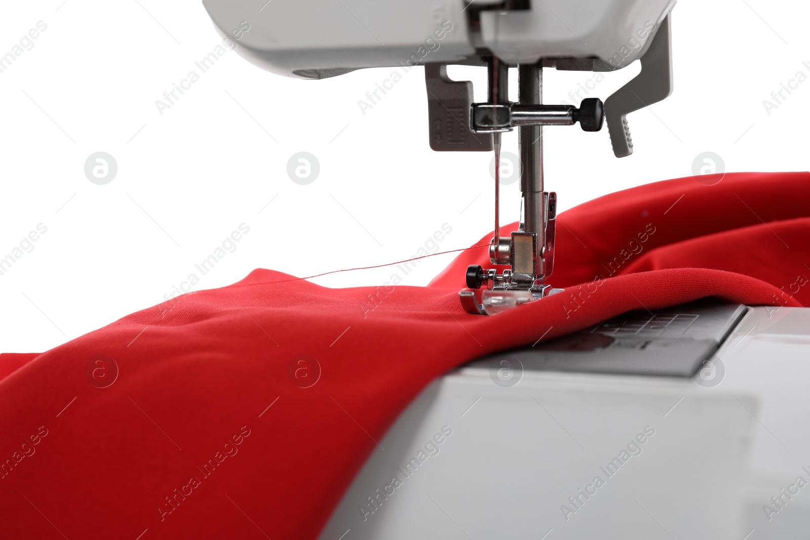 Photo of Sewing machine with red fabric isolated on white