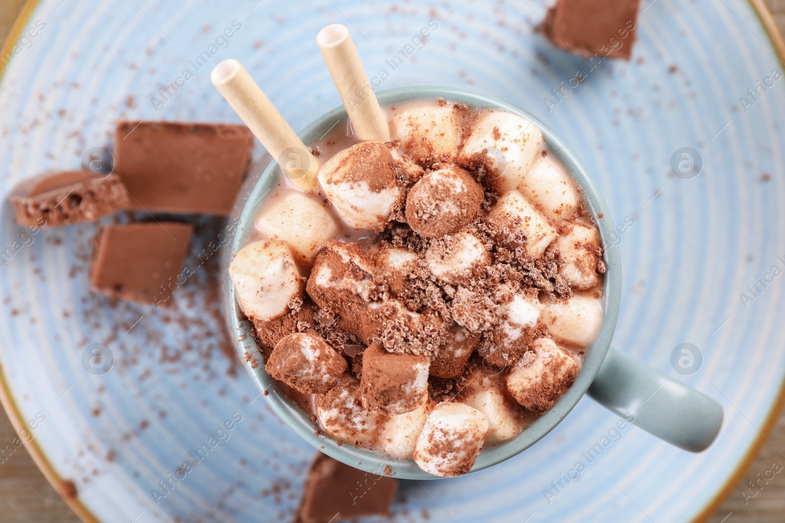 Photo of Cup of aromatic hot chocolate with marshmallows and cocoa powder on table, top view