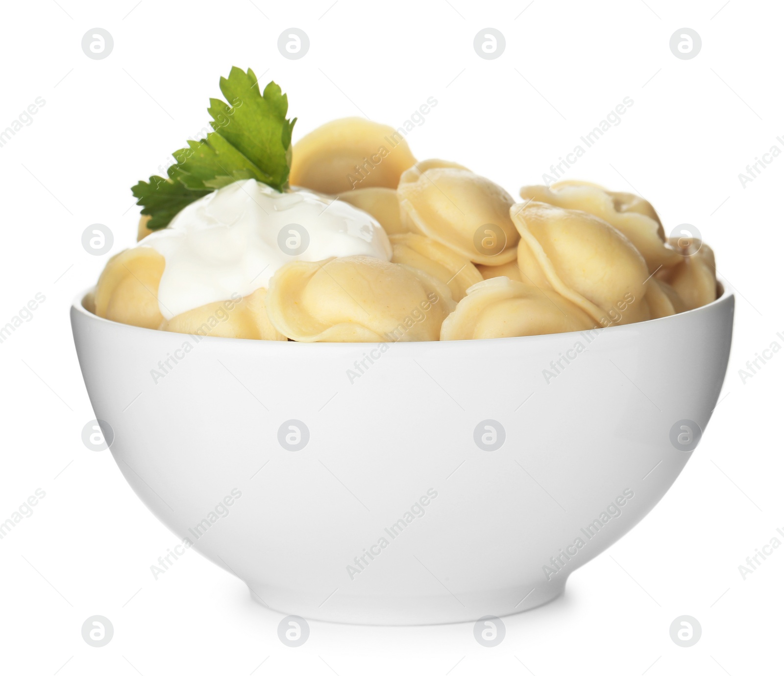 Photo of Tasty dumplings with sour cream and parsley in bowl isolated on white