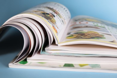 Photo of Stack of magazines on light blue background, closeup