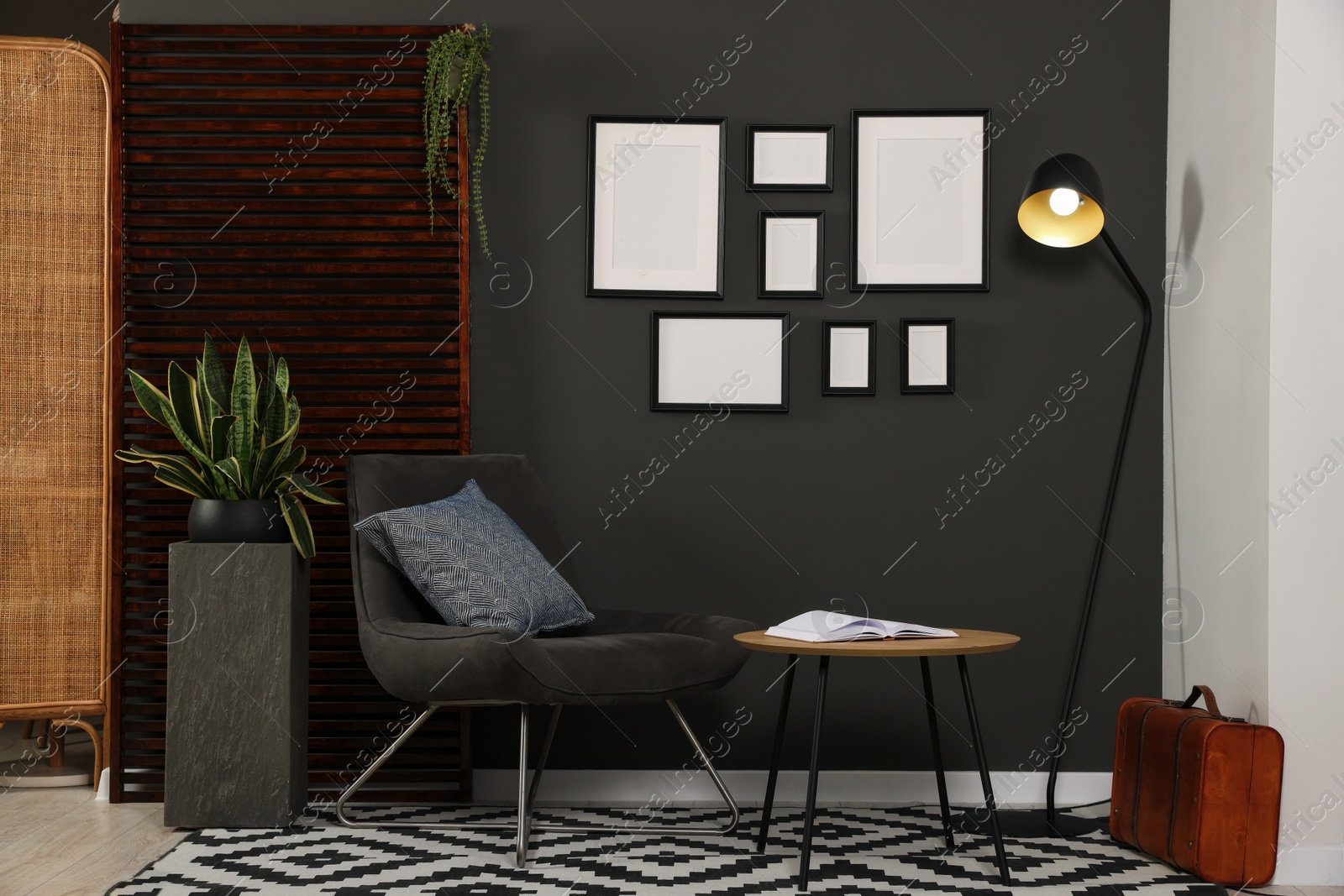 Photo of Empty frames hanging on black wall in stylish room. Mockup for design