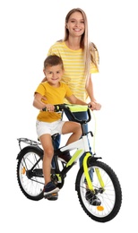 Young mother teaching son to ride bicycle on white background