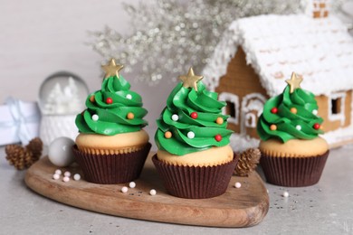 Photo of Christmas tree shaped cupcakes on light grey table