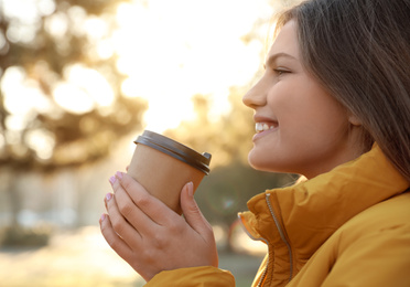 Young woman with cup of coffee in morning outdoors