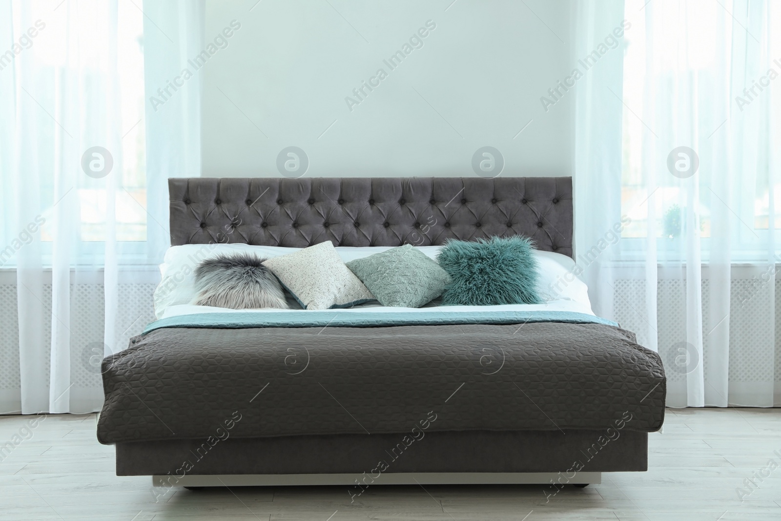 Photo of Comfortable bed with pillows and plaid in modern room interior
