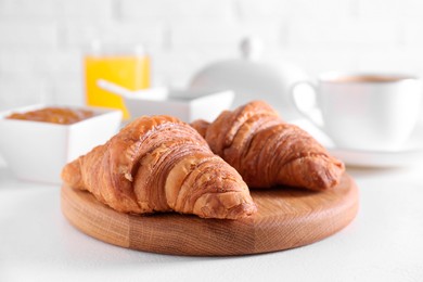 Photo of Fresh croissants on white table. Tasty breakfast