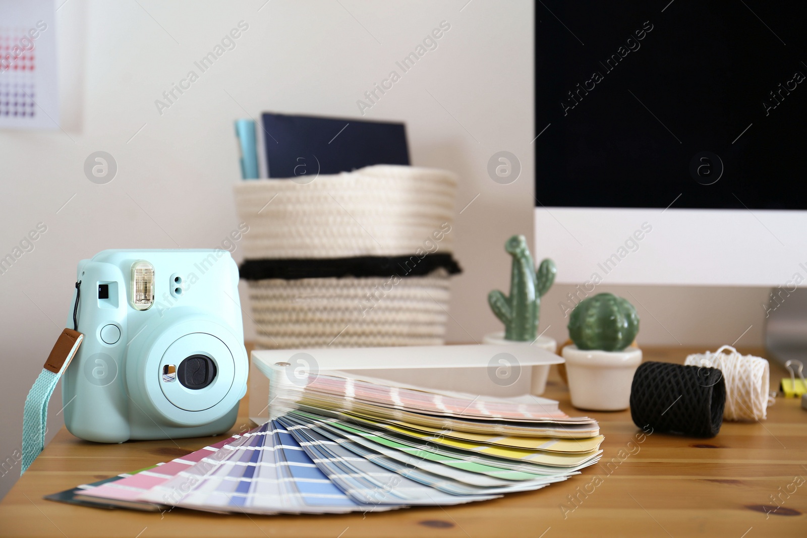 Photo of Digital camera and color palette on table in studio. Modern designer's workplace