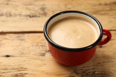 Cup of aromatic coffee on wooden table, closeup. Space for text