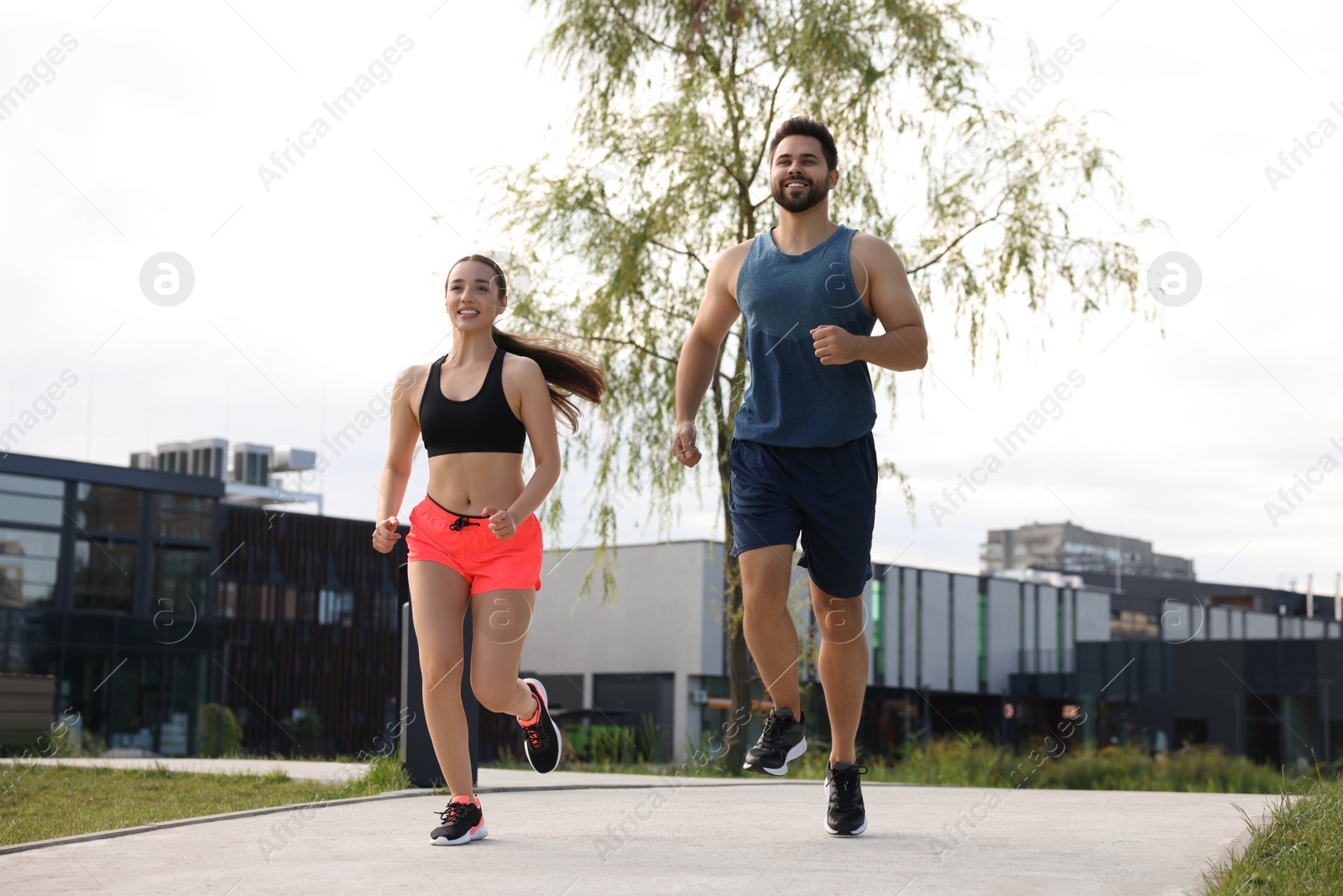 Photo of Healthy lifestyle. Happy couple running outdoors, low angle view