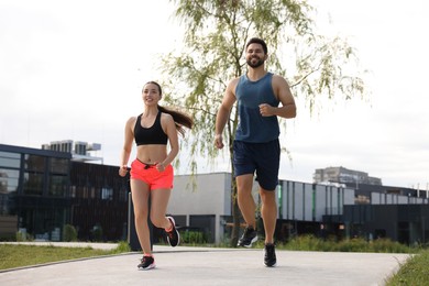 Healthy lifestyle. Happy couple running outdoors, low angle view
