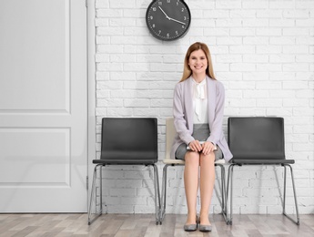 Photo of Young woman waiting for job interview, indoors