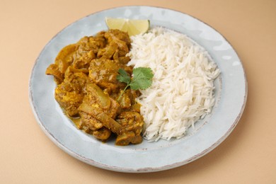 Photo of Delicious chicken curry with rice on beige background, closeup