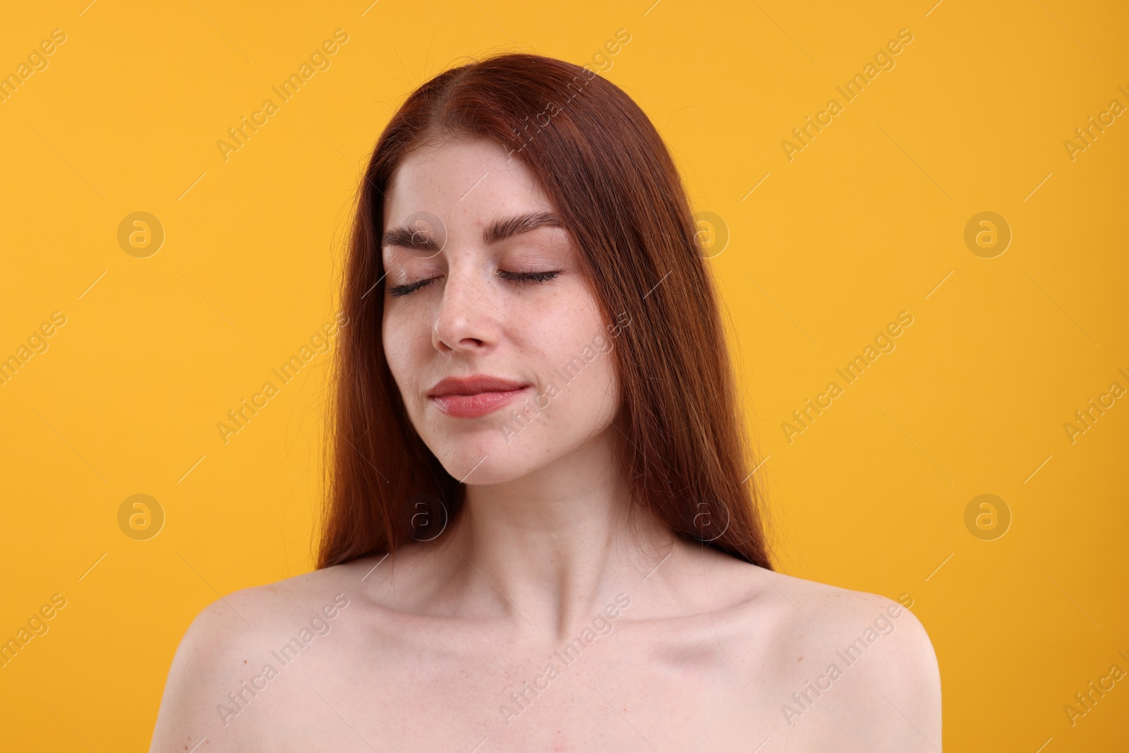 Photo of Portrait of beautiful woman with freckles on yellow background