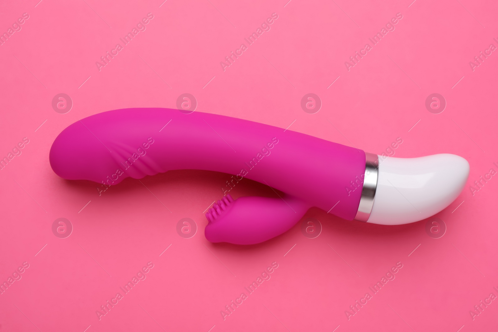 Photo of Vaginal vibrator on pink background, top view. Sex toy