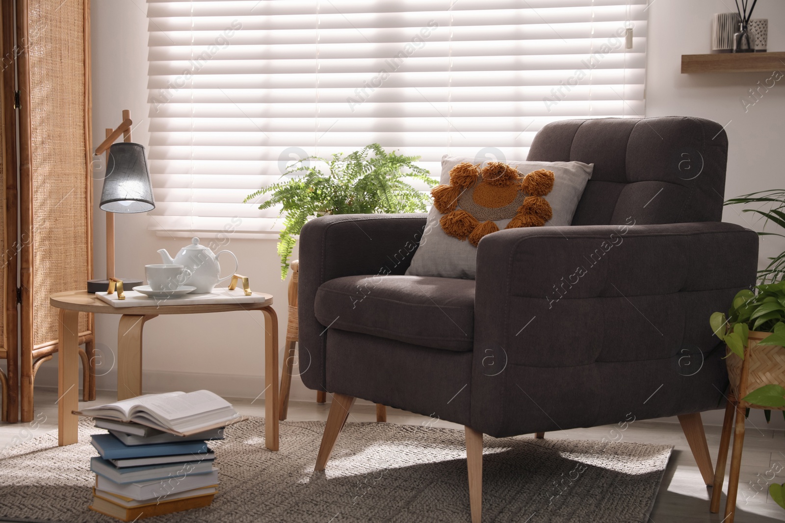 Photo of Comfortable place for rest with armchair near window in room