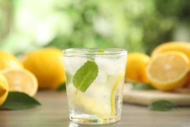 Photo of Cool freshly made lemonade in glass on wooden table, closeup