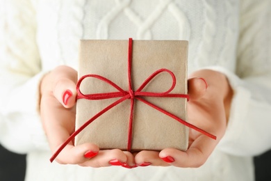 Photo of Woman holding beautiful Christmas gift with bow, closeup