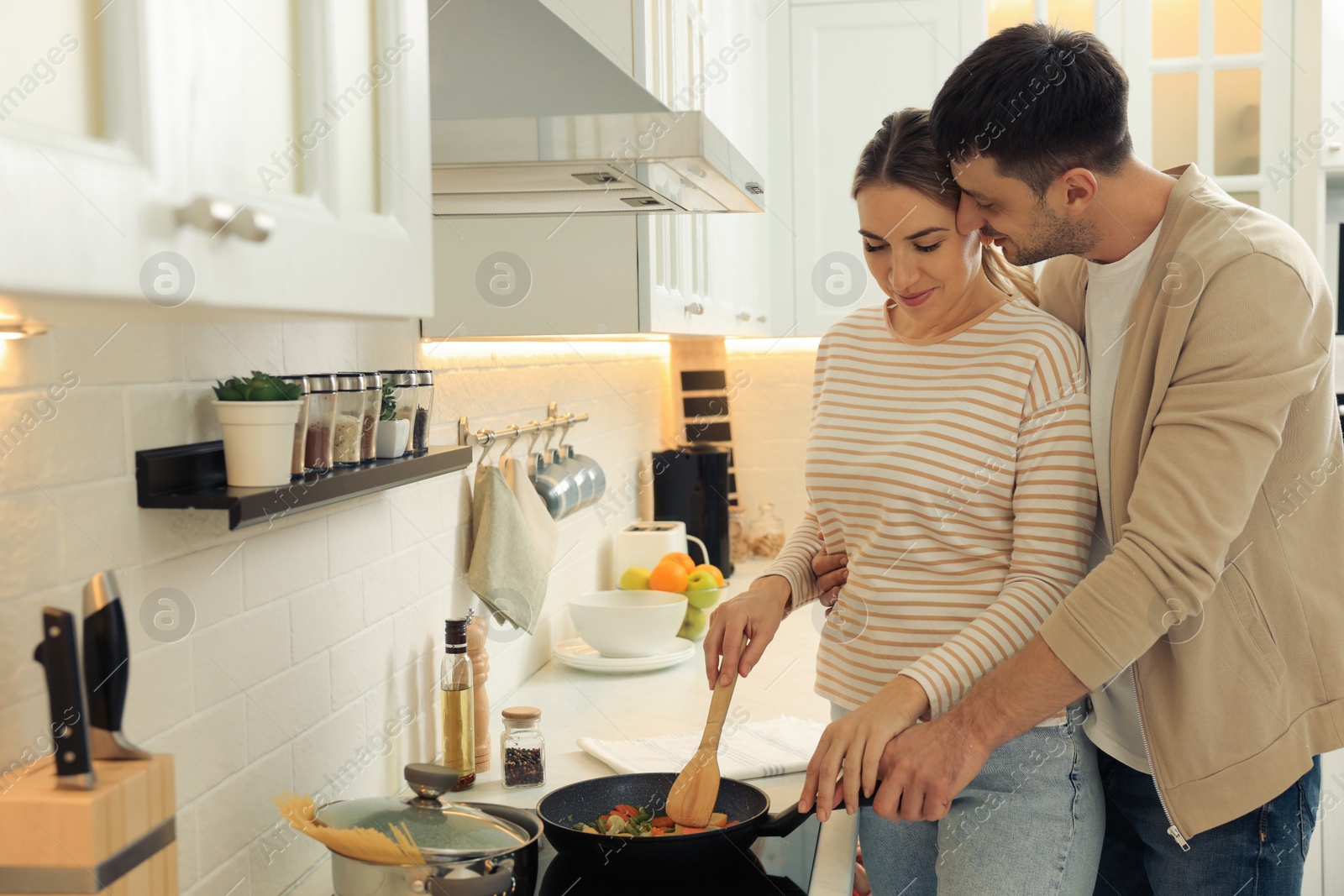 Photo of Happy couple preparing breakfast together in kitchen