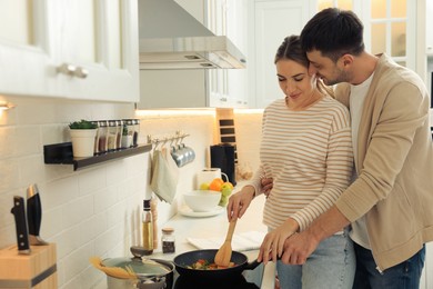 Photo of Happy couple preparing breakfast together in kitchen