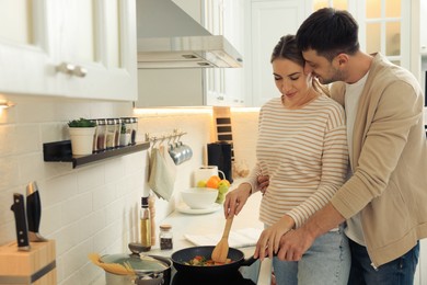 Happy couple preparing breakfast together in kitchen