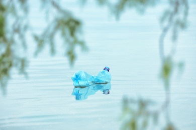 Used plastic bottle floating on water surface. Recycling problem