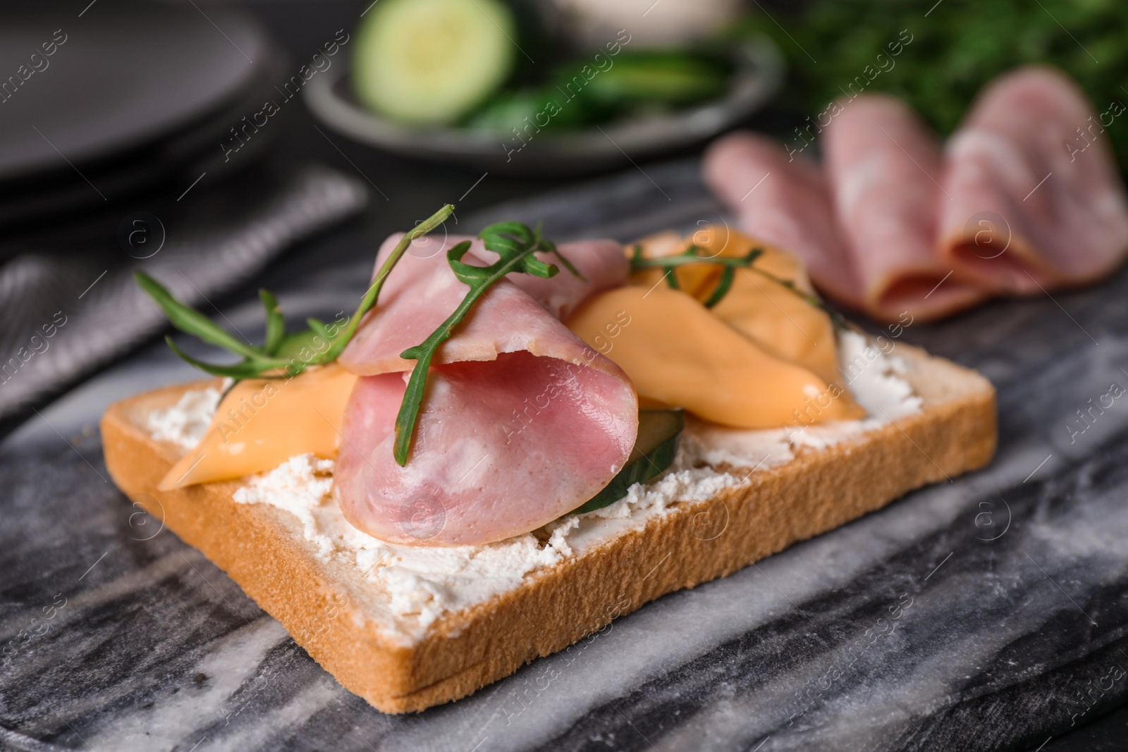 Photo of Delicious sandwich with ham on marble table, closeup