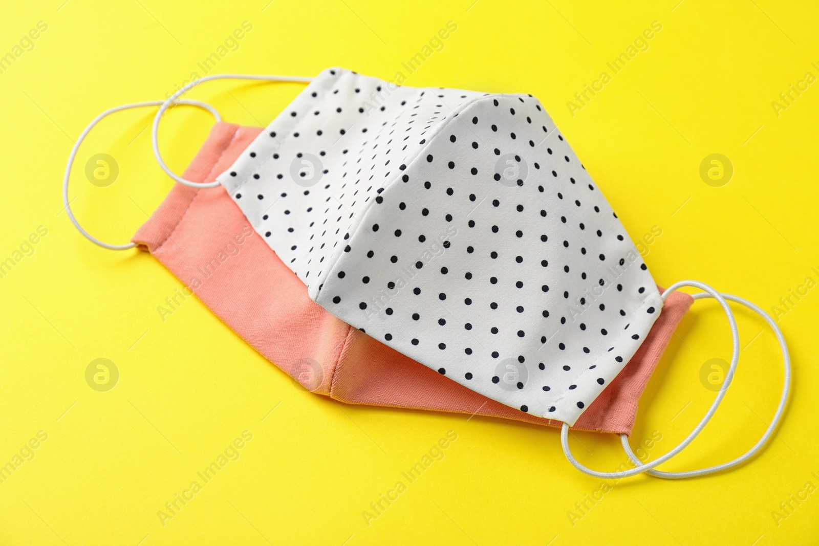 Photo of Homemade protective face masks on yellow background