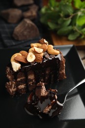 Photo of Piece of tasty homemade chocolate cake with nuts on plate, closeup