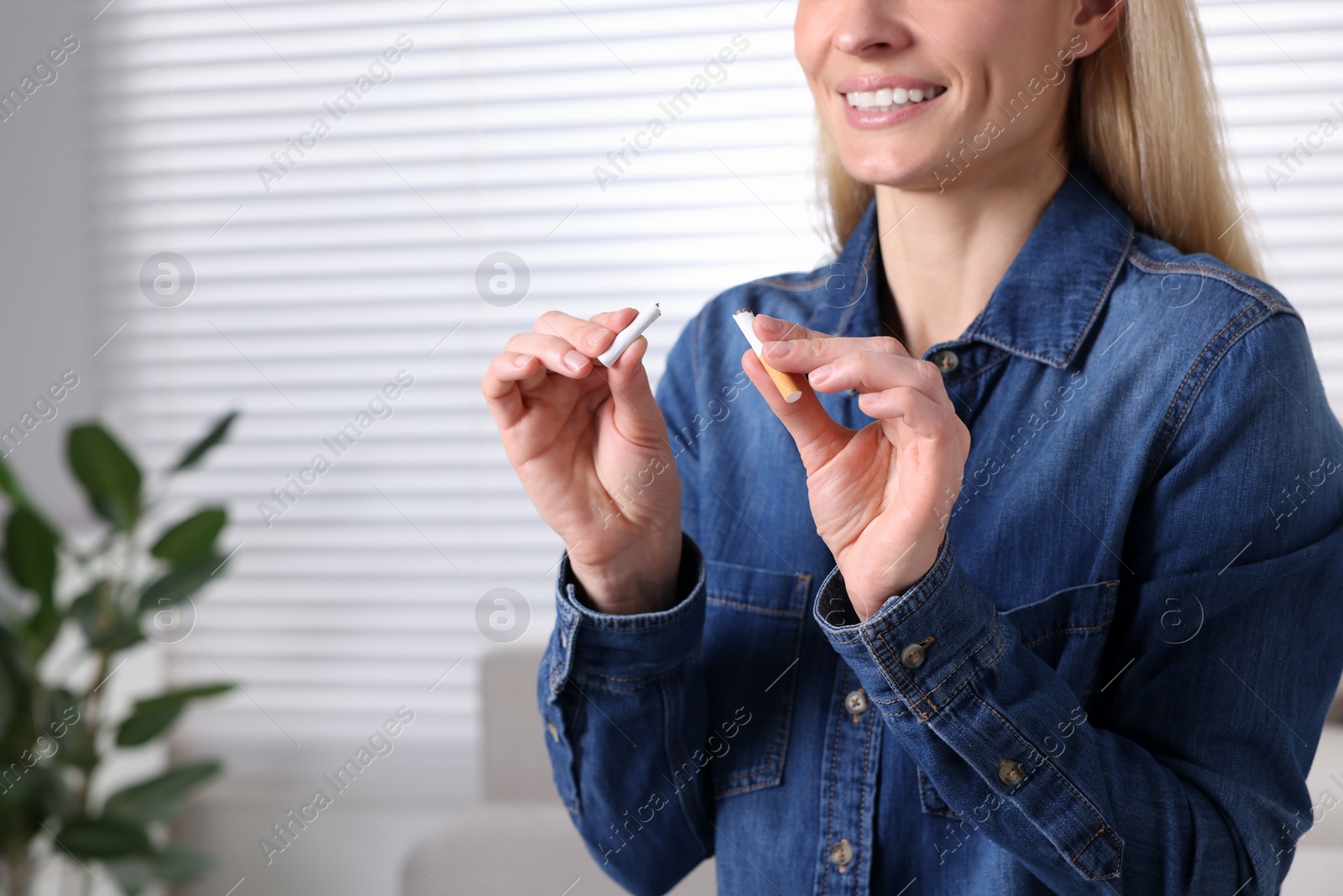 Photo of Quitting smoking concept. Woman with broken cigarette on blurred background, closeup. Space for text