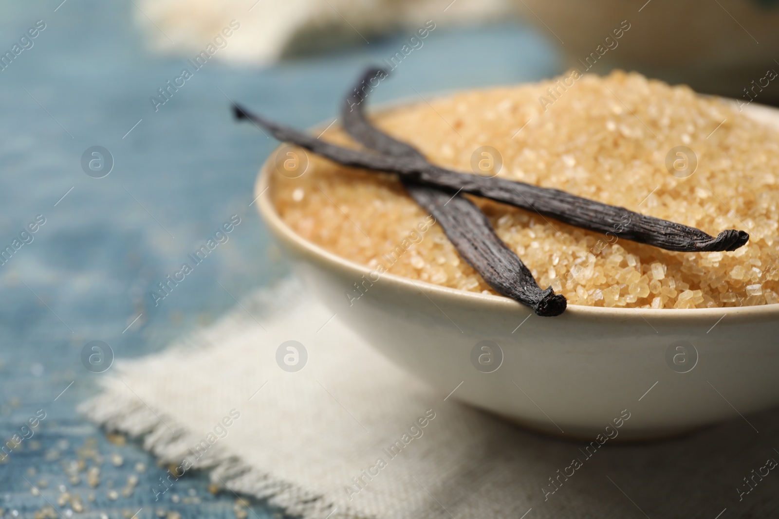 Photo of Bowl with brown vanilla sugar on wooden table