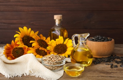 Photo of Composition with sunflower oil on wooden table