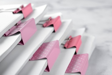 Photo of Stack of documents with binder clips on marble table, closeup