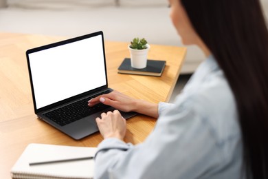 Photo of Young woman watching webinar at table indoors, closeup