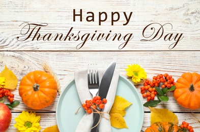 Image of Happy Thanksgiving Day card. Flat lay composition with tableware, autumn leaves and pumpkins on white wooden table