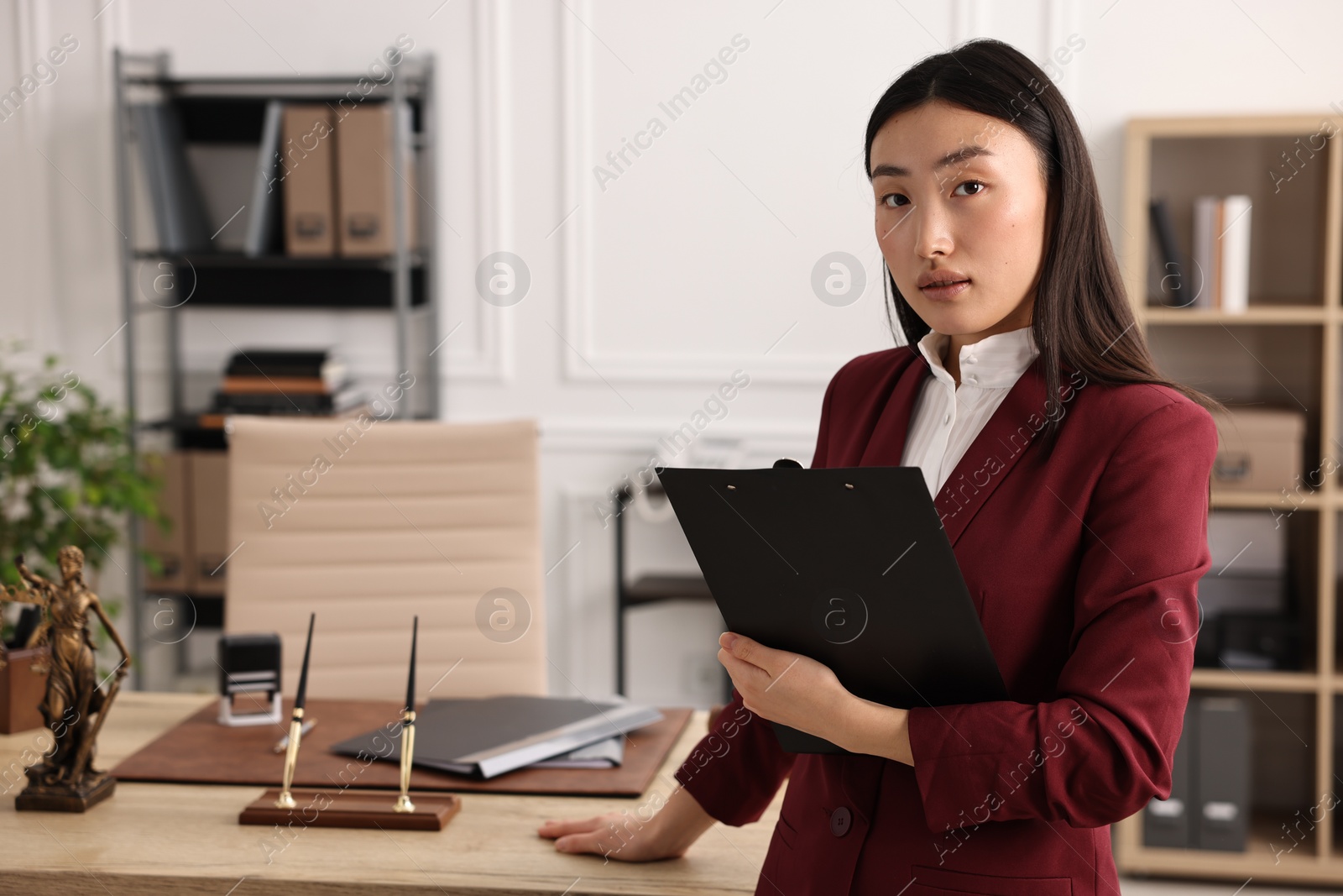 Photo of Portrait of notary with clipboard in office. Space for text