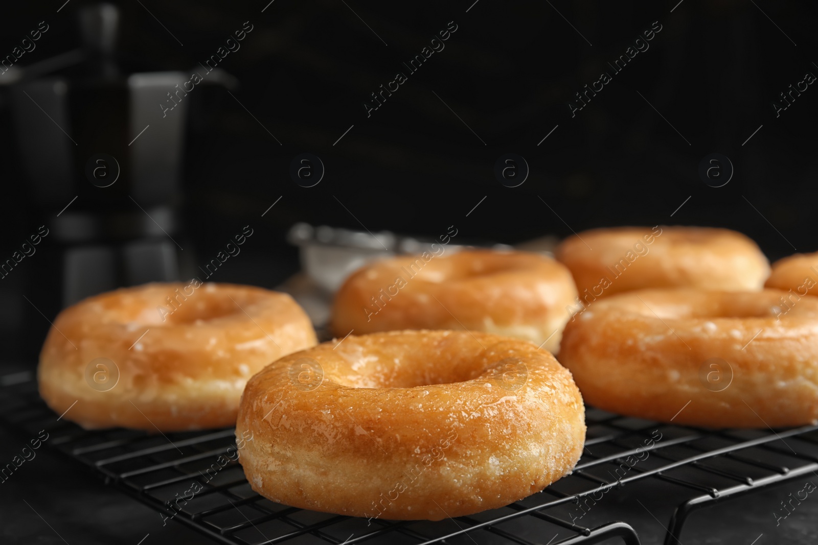 Photo of Sweet delicious glazed donuts on black table