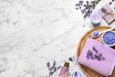 Photo of Cosmetic products and lavender flowers on white marble table, flat lay. Space for text