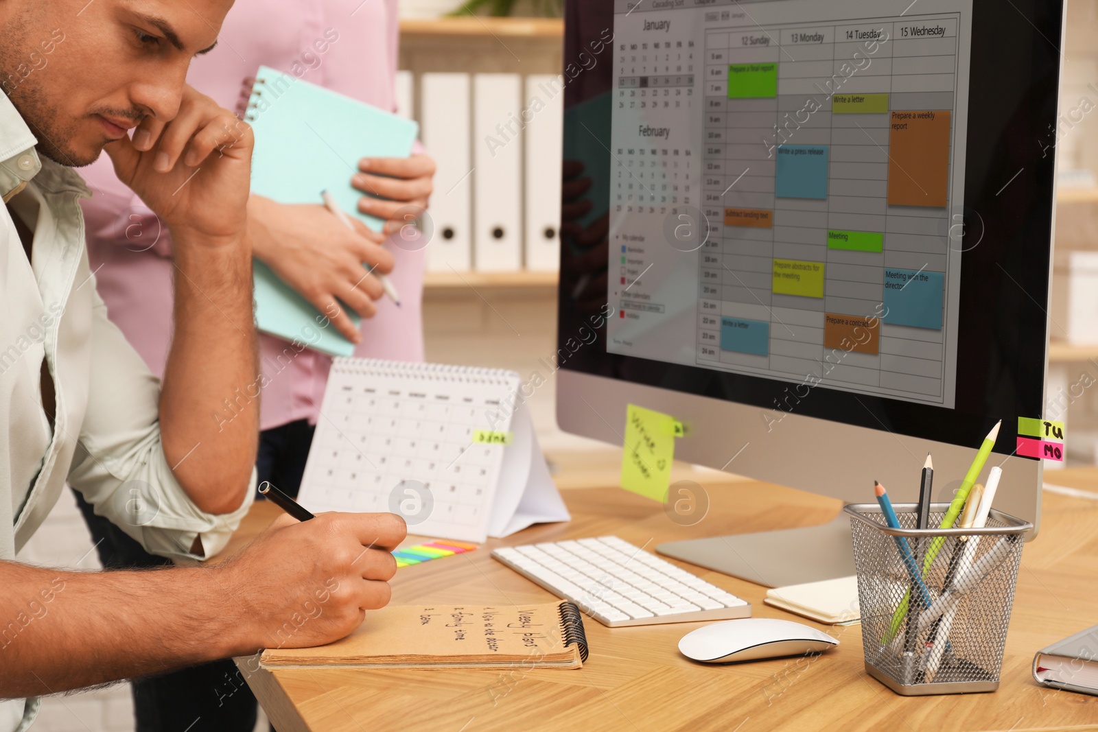 Photo of Colleagues working with calendar app on computer in office, closeup