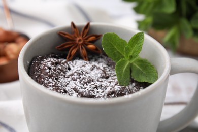 Photo of Tasty chocolate mug pie with anise and mint on table, closeup. Microwave cake recipe