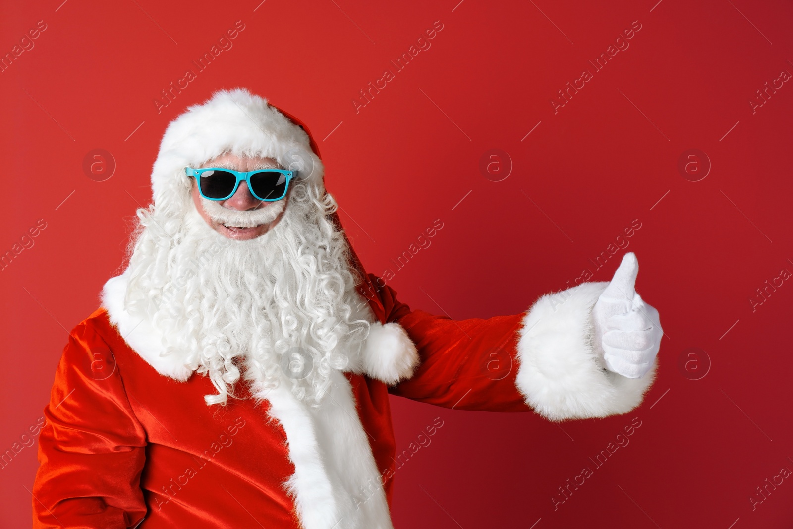 Photo of Authentic Santa Claus wearing sunglasses on color background