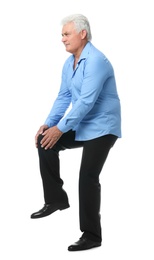 Full length portrait of senior man having knee problems on white background