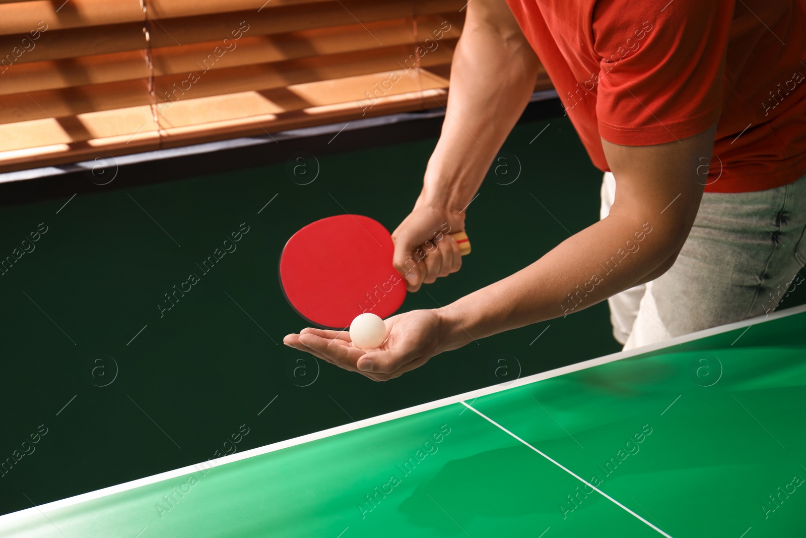 Photo of Man playing ping pong indoors, closeup view