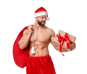 Photo of Attractive young man with muscular body in Santa hat holding bag and Christmas gift box on white background