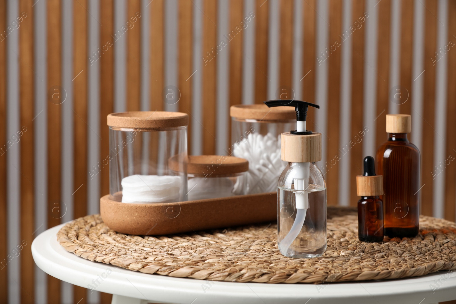 Photo of Bottle with dispenser cap and essential personal hygiene products on table indoors