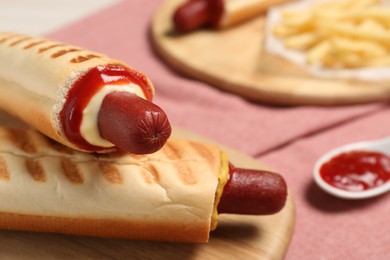 Photo of Delicious french hot dogs, fries and dip sauce on table, closeup