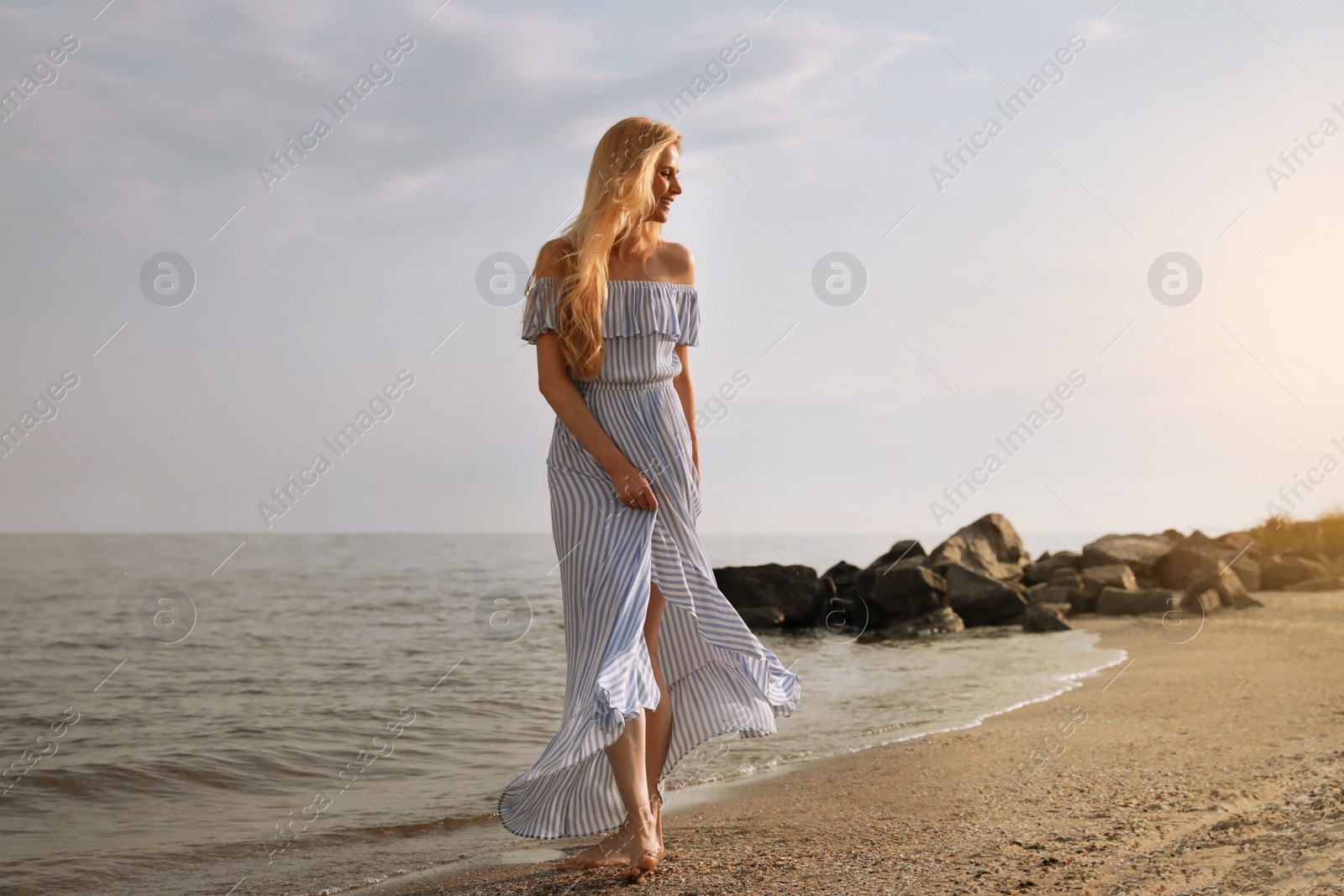 Photo of Beautiful young woman near water on sea beach