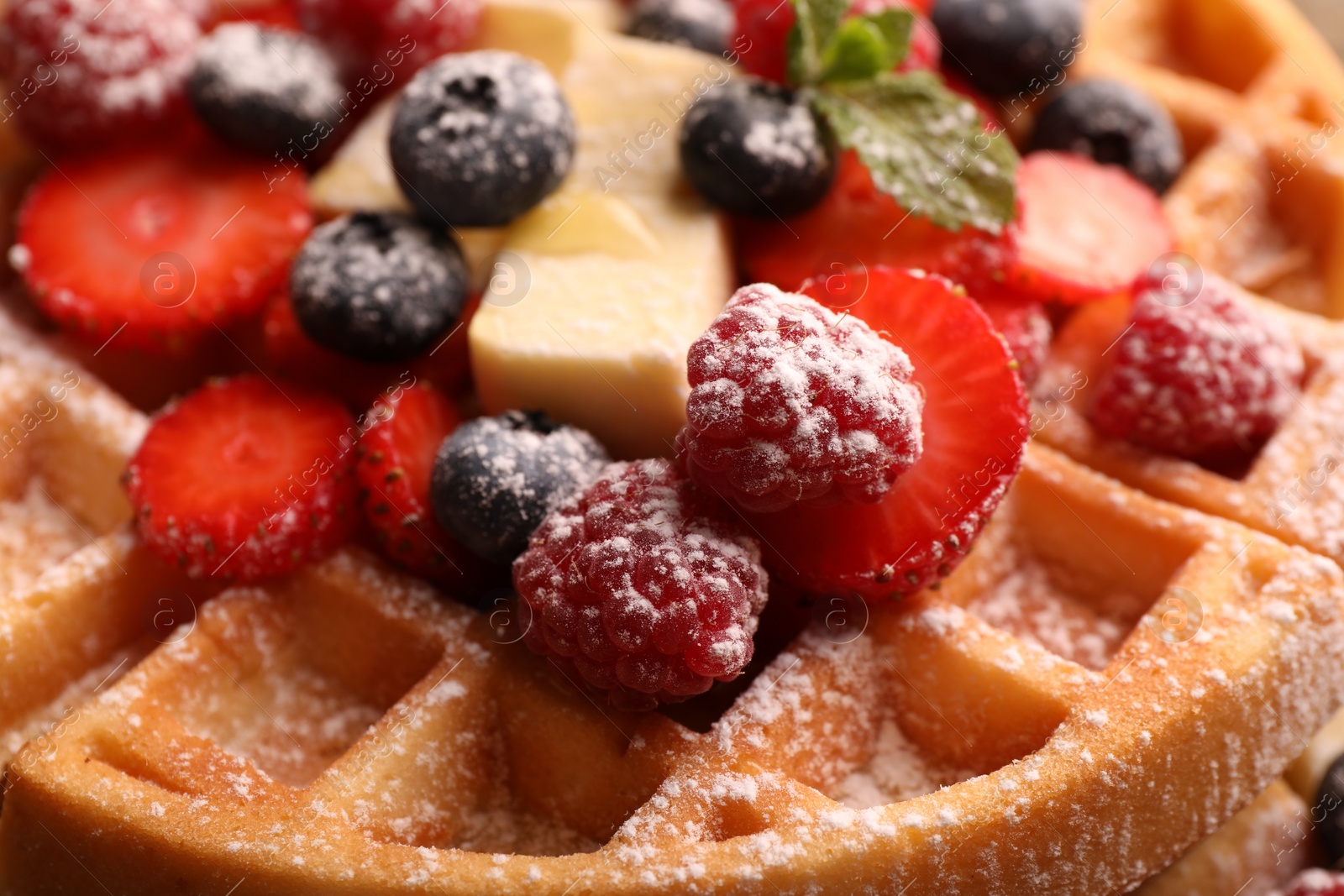 Photo of Tasty Belgian waffle with fresh berries, cheese and powdered sugar, closeup