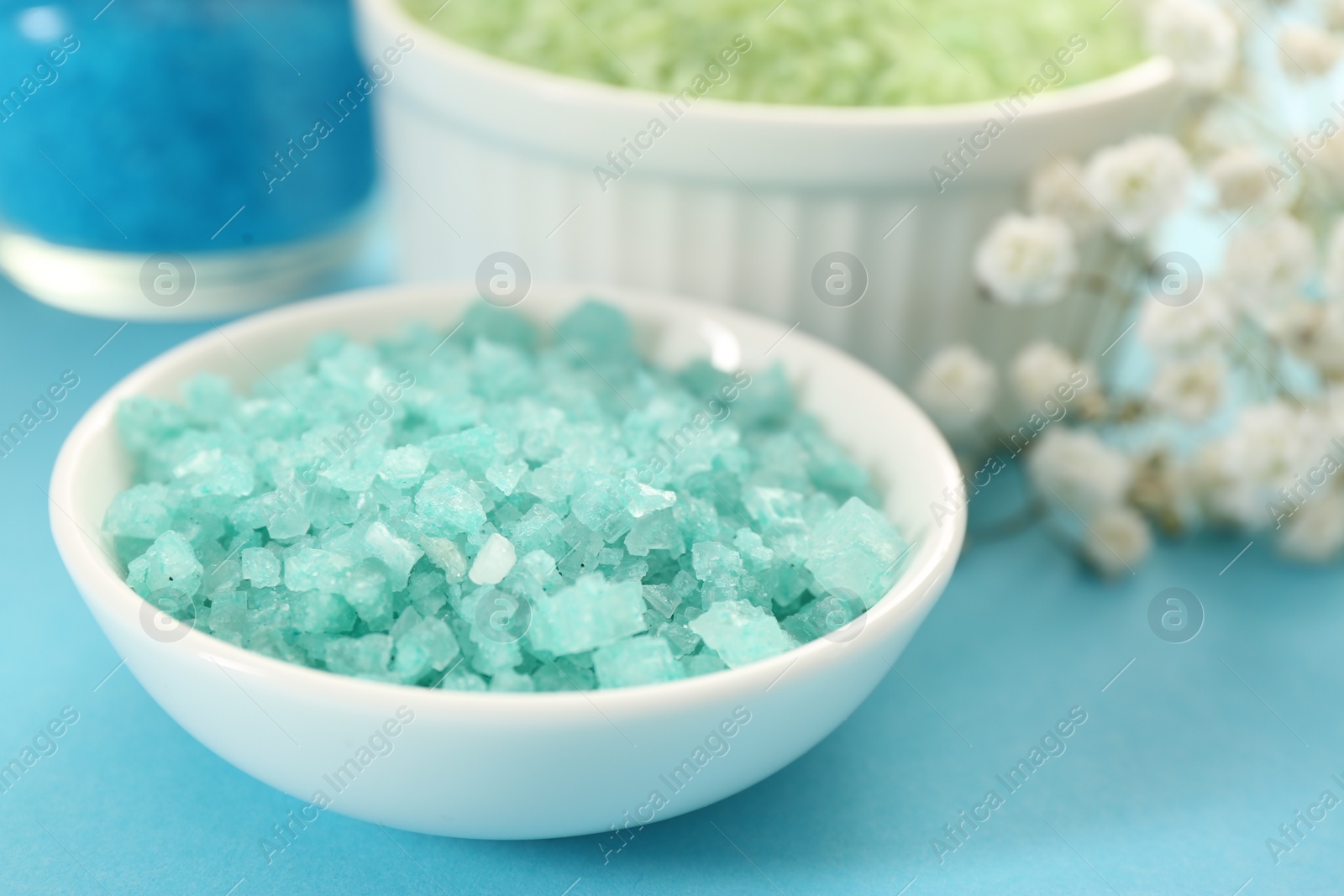 Photo of Aromatic sea salt on light blue background, closeup